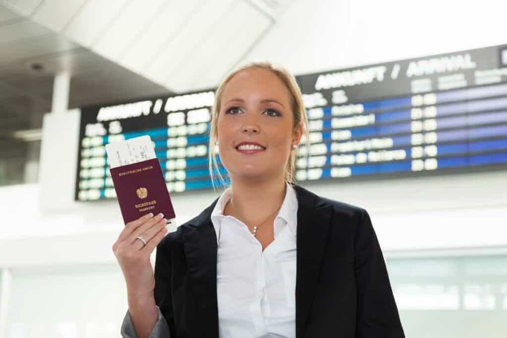 אישה מחזיקה דרכון אוסטרי עם כרטיס טיסה שיוצא ממנו